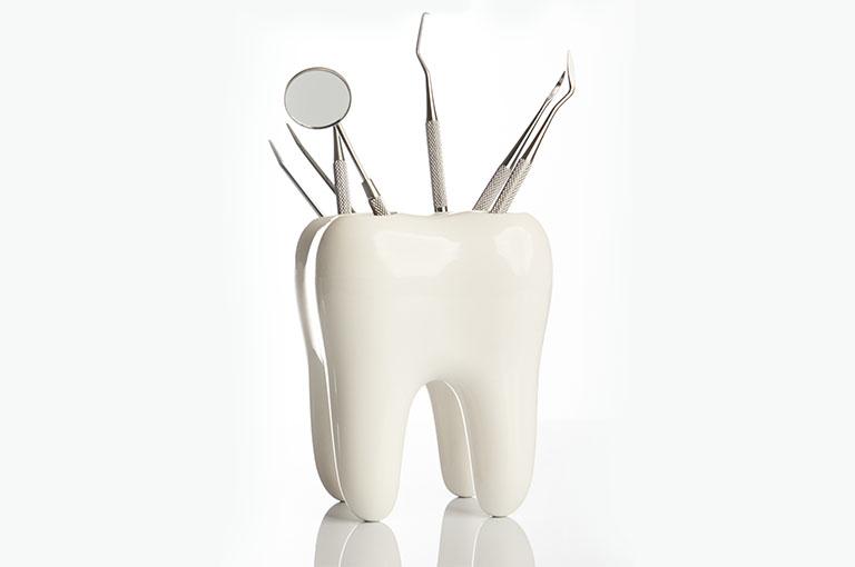 Kubek na narzędzia stomatologiczne wyglądający jak ząb